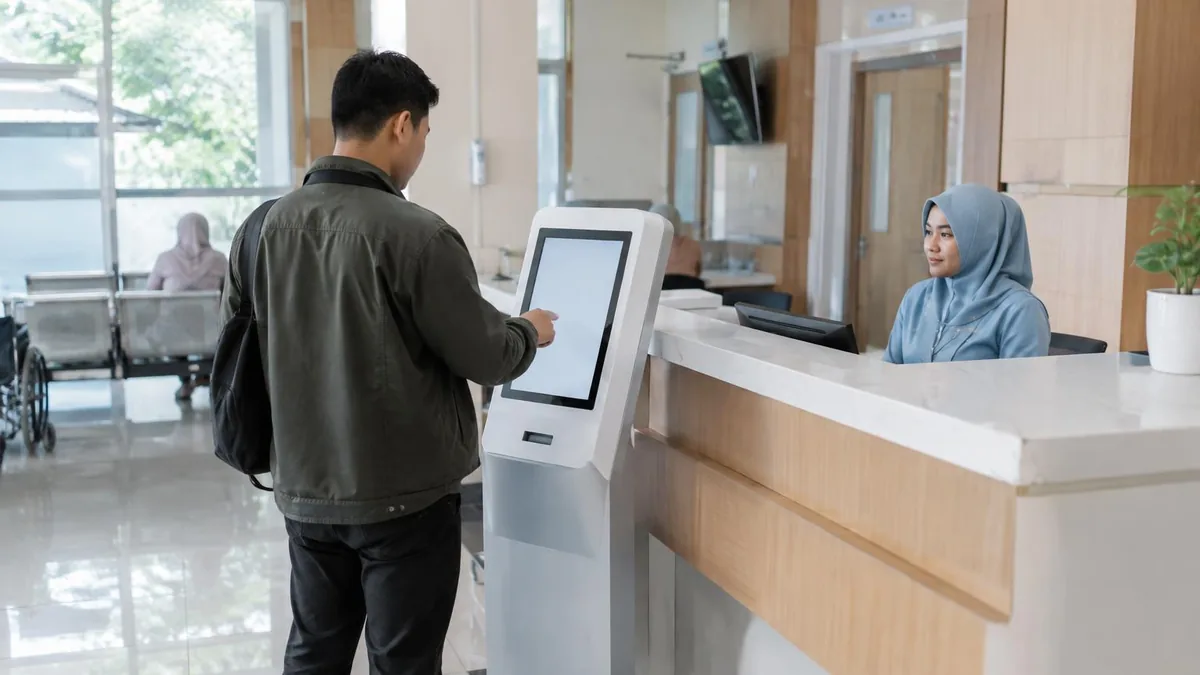 Pasien menggunakan kiosk antrian generik di area penerimaan rumah sakit